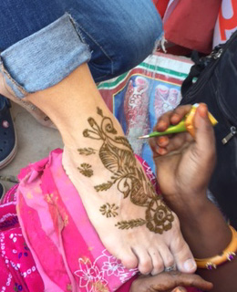 TravelAstu guest with a heena tattoo artist in Delhi